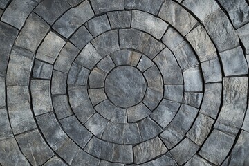Intricate circular pattern of textured stone paving.
