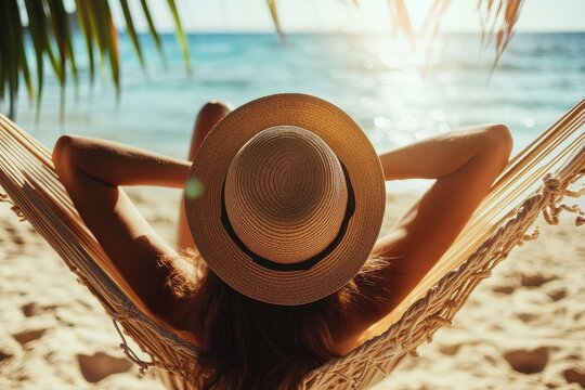 Woman relaxing in hammock by tranquil seaside at sunset.