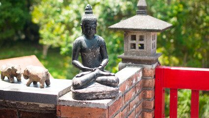 An old hindu stone statue of Buddha standing in the house on the Bali