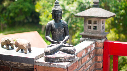 An old hindu stone statue of Buddha standing in the house on the Bali