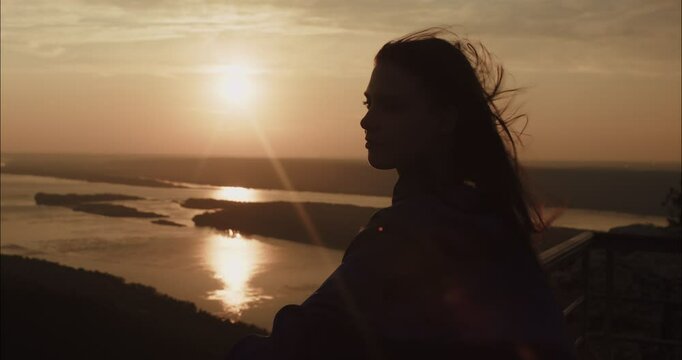 Young woman feeling the wind on her face at sunset