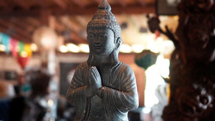 An old hindu stone statue of Buddha standing in the house on the Bali