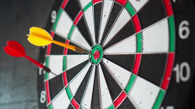 A dart board hangs on a black wall with darts stuck into it