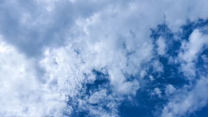 Clear blue sky with scattered cotton-like clouds