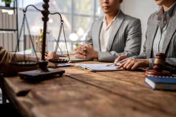 A man and a woman are sitting at a table with a scale and a gavel