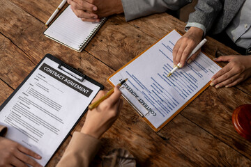 Naklejka premium A group of people are sitting around a table with papers and pens