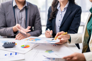 Three people are sitting at a table with papers and a calculator