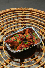 Homemade baked chicken breast in the aluminum foil box served on the table barbeque grill....