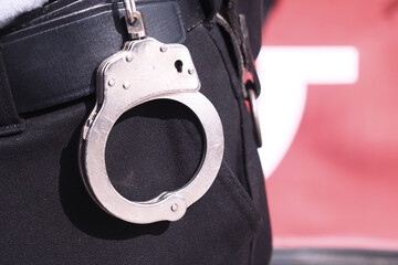 Police officer wearing handcuffs during a law enforcement activity