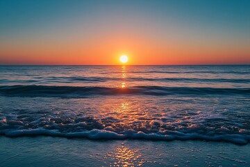 Naklejka premium A beautiful orange sun setting over the ocean horizon