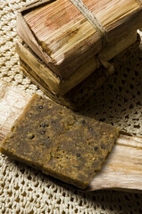 Pinonate, traditional spanish sweet wrapped in palm leaves, resting on rustic doily