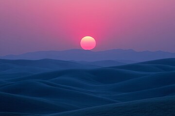 Obraz premium The vibrant pink sun sets above rolling hills in the twilight