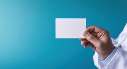 Fototapeta premium World Health Day concept, close-up of a doctor's hand holding a clean white empty card, medical profession, alert, message template card, doctors business card mockup