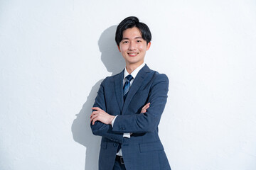 腕組みをするスーツを着た男性の横顔