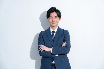 腕組みをするスーツを着た男性の横顔