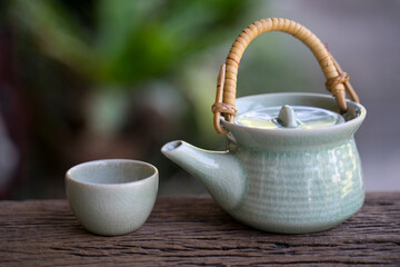 Hot teapot and glass on wooden background