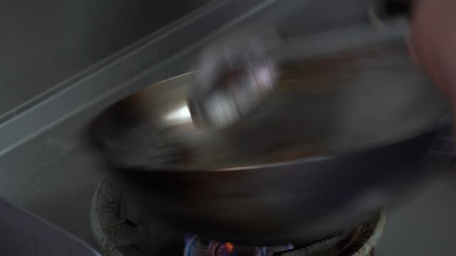 Asian Chef Stir frying tomatoes and onions