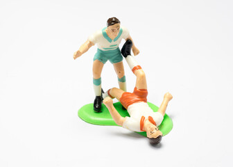 A soccer player toy is playing football.