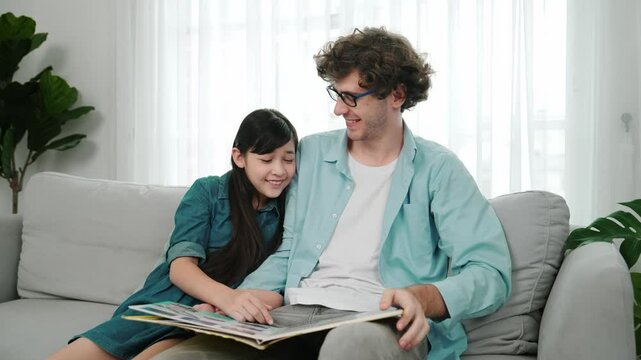 Happy dad telling story and moving gesture while funny schoolgirl pointing at story book. Student listen and enjoy talking about fairytail while looking parent. Family recreation concept. Pedagogy.
