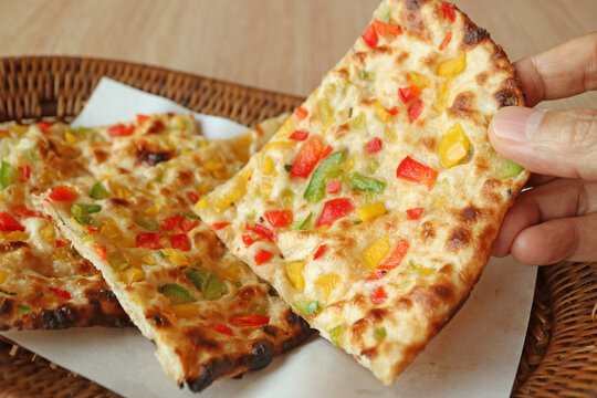 Hand Picking a Slice of Chili Naan from Wicker Basket	