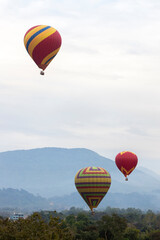 Obraz premium Colorful hot air balloons flying over mountain