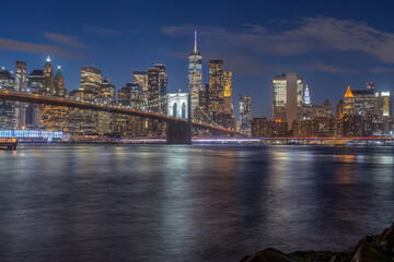 Fototapeta premium The iconic Brooklyn Bridge and the skyline of lower Manhattan in New York City at night