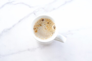 淹れたてのコーヒー（カフェラテ）が入ったマグカップを、真上から俯瞰した画像
