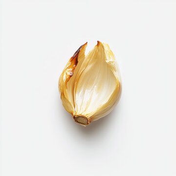 Single roasted garlic clove displaying rich golden color on a plain white background