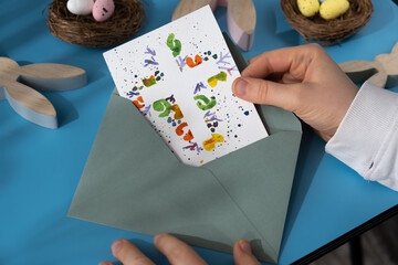 Person holding handmade greeting card with message CHRIST THE LORD IS RISEN TODAY written in...