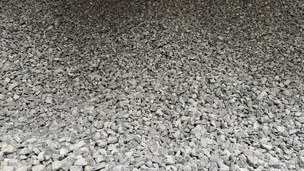Top view of granite stones outdoor. Crushed fraction granite background. Textured gray stone for background.