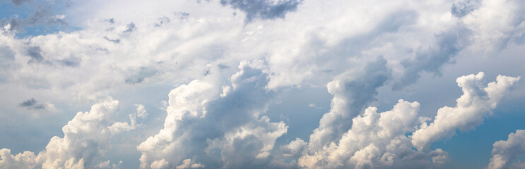 panorama of the sky with large cumulus clouds forming a dynamic pattern