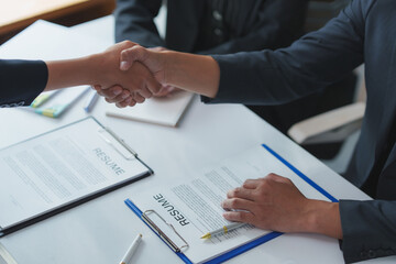 Businesspeople shaking hands after successful job interview and resume review