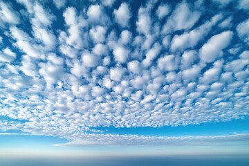 Cotton candy clouds drift above the calm ocean on a sunny summer afternoon