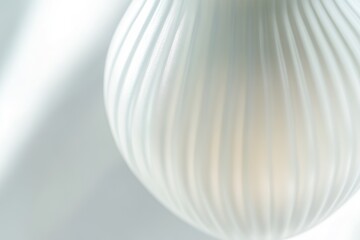 Close-up of a ribbed, off-white, pearlescent lampshade, softly lit.
