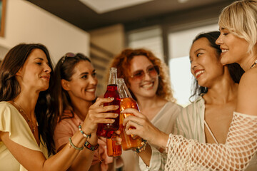 Happy group of diverse friends toasting drinks at a party