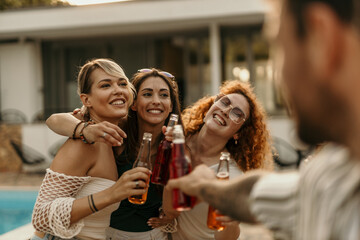 Friends dancing and enjoying drinks together at a pool party
