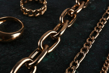 Obraz premium Beautiful chain bracelets and rings on black background