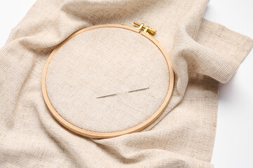 Wooden embroidery hoop with needle isolated on white background