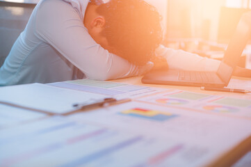 Exhausted man feeling tried of overload work felt to sleep on desk in office