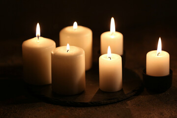 Beautiful burning candles on black background