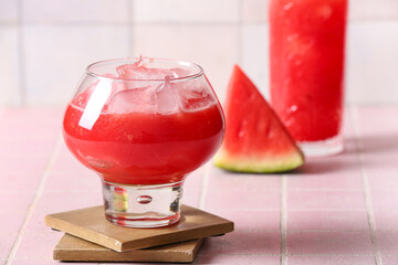 Glass of tasty watermelon fresh on pink tile background