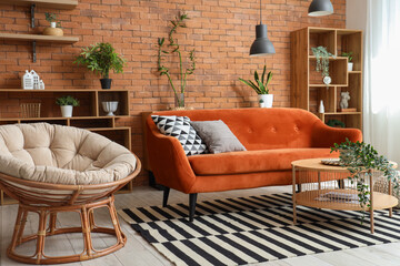 Interior of living room with armchair, red sofa and houseplants