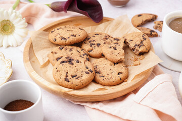 Plate of tasty cookies with chocolate chips on white background