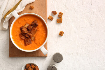 Pot of tasty cream soup with croutons on white background