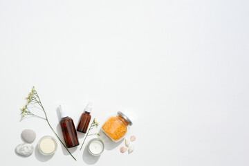 Glass skincare bottles, candles, and bath salts create a natural beauty display, natural composition supporting clean beauty trends, natural arrangement emphasizing self-care essentials