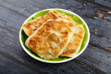 Healthy whole wheat delicious porattas served on a white plate.