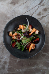 A beautifully arranged salad featuring succulent shrimp, mixed greens, and vibrant garnishes invites diners to indulge in European culinary artistry at a restaurant table