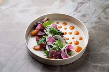 Enjoying a beautifully plated salad at a charming European restaurant, this dish showcases fresh greens, colorful radishes, and a delightful sauce. A feast for both the eyes and palate