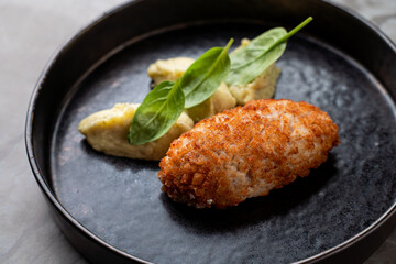 Enjoy European cuisine with golden croquettes, creamy potato dumplings, and vibrant spinach for a gourmet dining experience. Pure flavors on a beautifully presented dish!