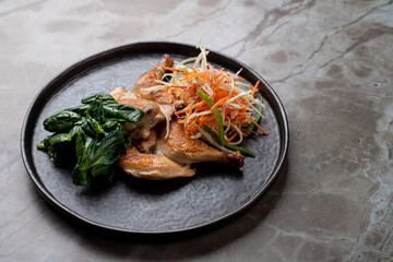 Delight in a culinary experience featuring a beautifully plated dish of succulent chicken accompanied by vibrant greens and a refreshing salad. A perfect moment for food lovers